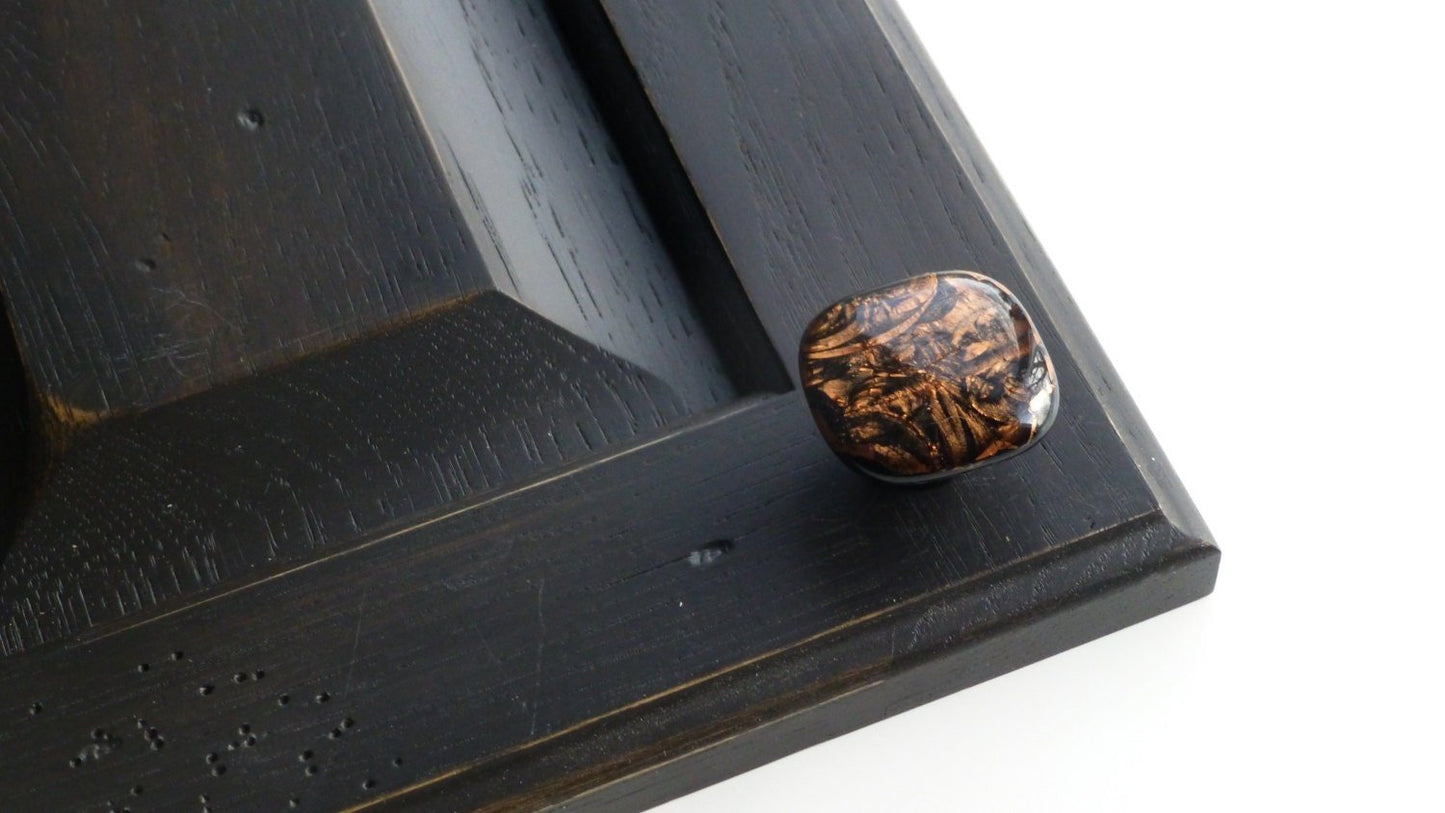 A copper pull installed on a black cabinet. Made in USA. Ann Ivory Studios.