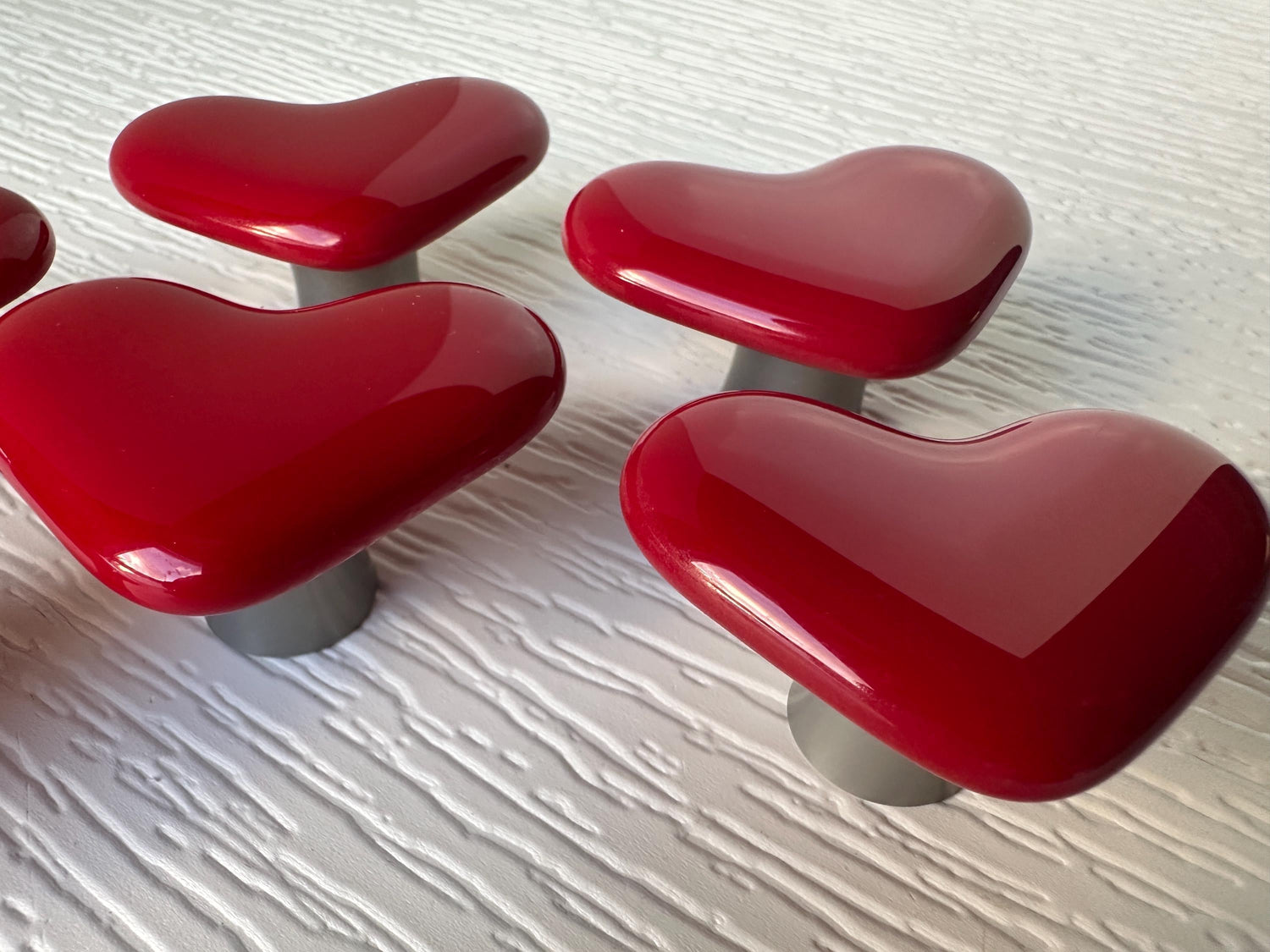 Heart cabinet knobs made from bright red glass.