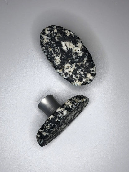 A pair sliced stone knobs with tones of black and white.